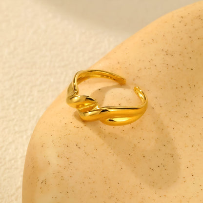Bague ouverte torsadée en acier inoxydable et or jaune vue de côté.