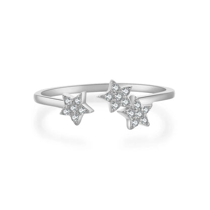 Bague ouverte trio d'étoiles en argent 925 rhodié et zircons sertis grains sur fond blanc.