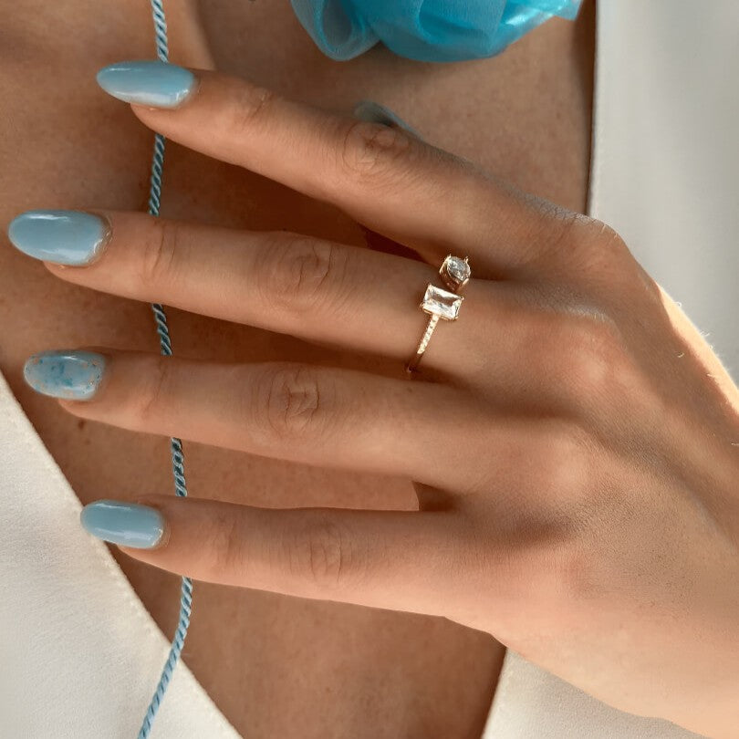 Bague ouverte en or jaune et diamants naturels portée au doigt d'une femme.