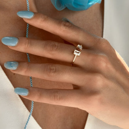 Bague ouverte en or jaune et diamants naturels portée au doigt d'une femme.