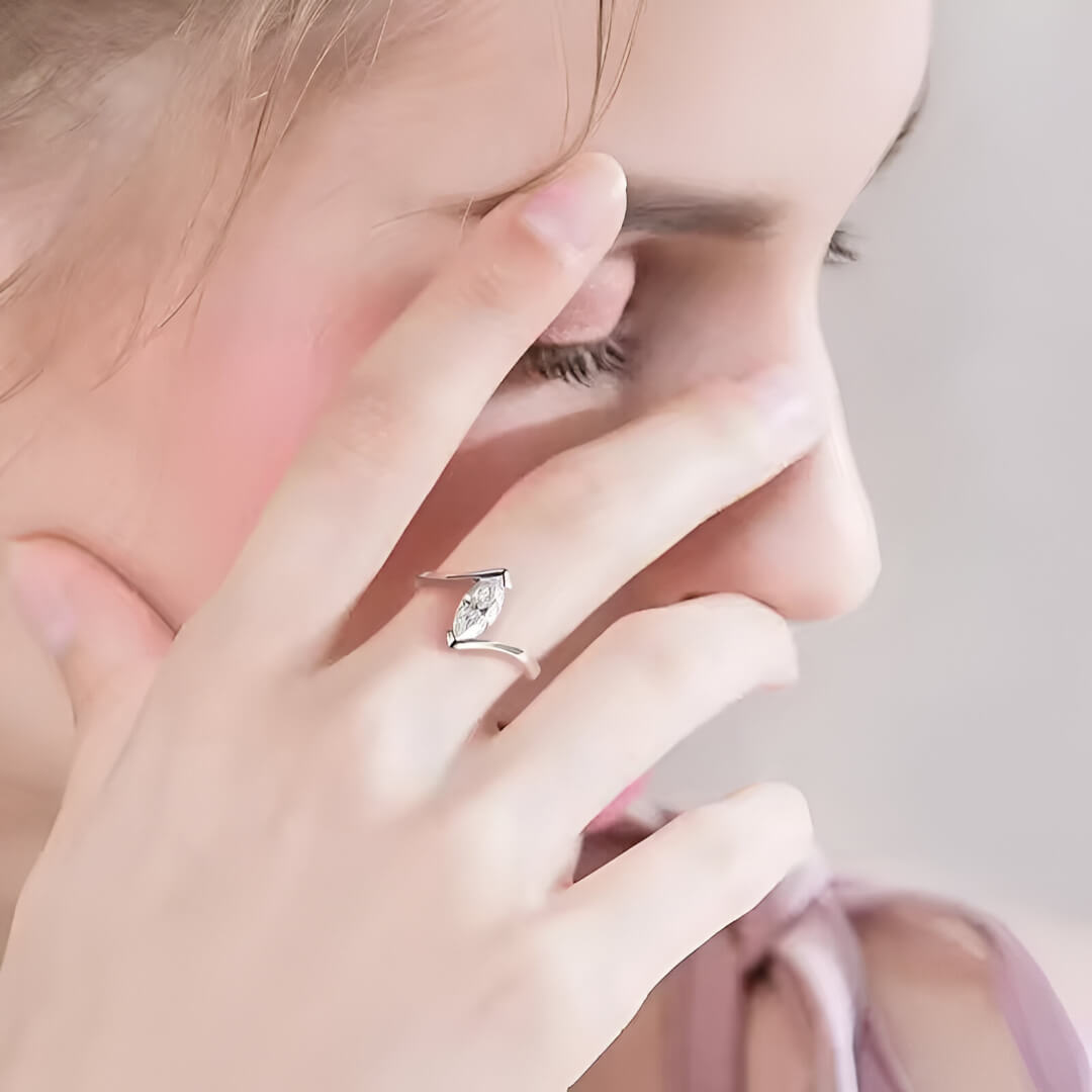 Bague solitaire en or blanc et diamant synthétique portée au doigt d'une femme.