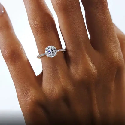 Bague solitaire Artemis en argent sterling 925 plaqué or jaune et diamants portée au doigt d'une femme vue du dessus.