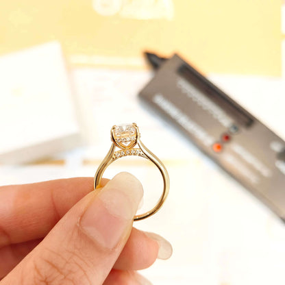 Bague solitaire en or jaune et diamant synthétique montrée par une main de femme vue latérale.