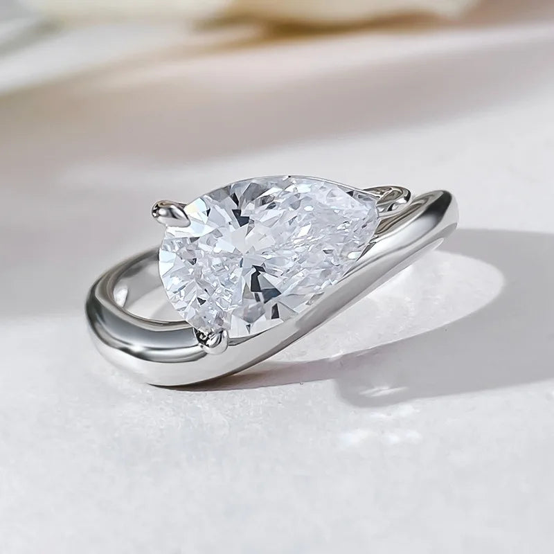 Bague solitaire courbée en or blanc et diamant synthétique à plat.