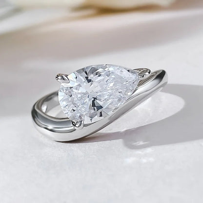 Bague solitaire courbée en or blanc et diamant synthétique à plat.