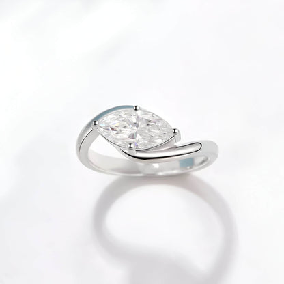 Bague solitaire courbée en or blanc et diamant synthétique sur fond blanc.