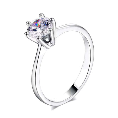 Bague solitaire en or blanc et oxyde de zirconium sur fond blanc.