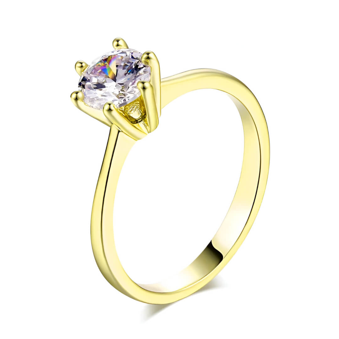 Bague solitaire en or jaune et oxyde de zirconium sur fond blanc.