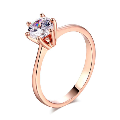 Bague solitaire en or rosé et oxyde de zirconium sur fond blanc.