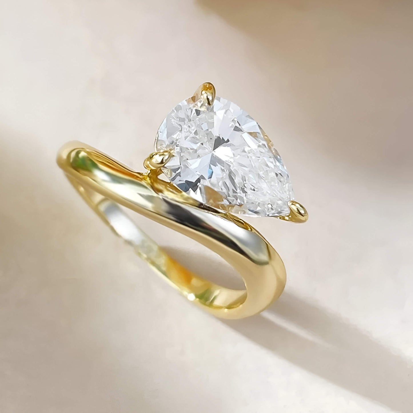 Bague solitaire incurvée en argent 925 plaqué or jaune chaleureux et diamant forme goutte vue du dessus.