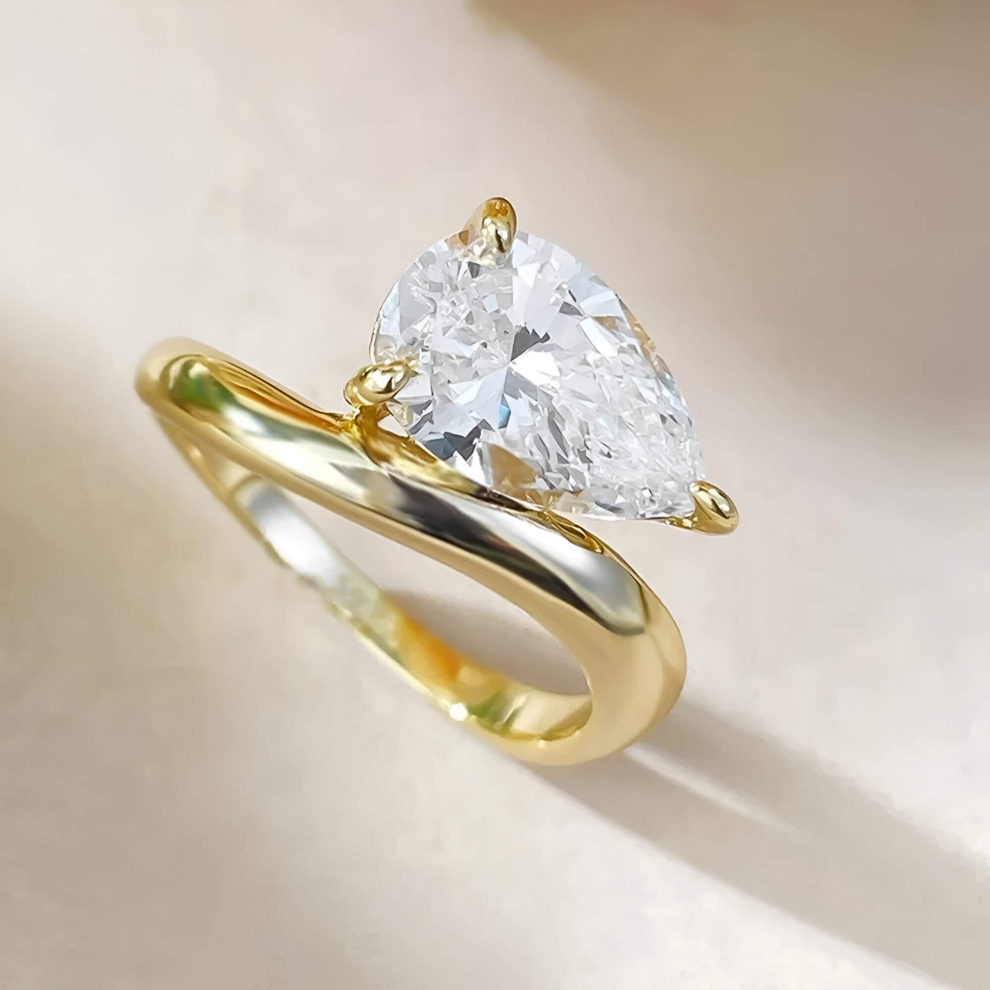 Bague solitaire incurvée en argent 925 plaqué or jaune chaleureux et diamant forme goutte vue du dessus.