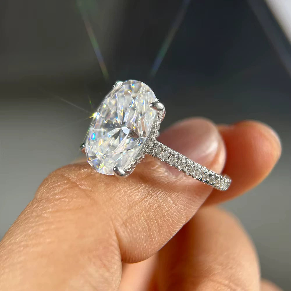 Bague solitaire en or blanc et diamants synthétiques sur un doigt vue de côté.