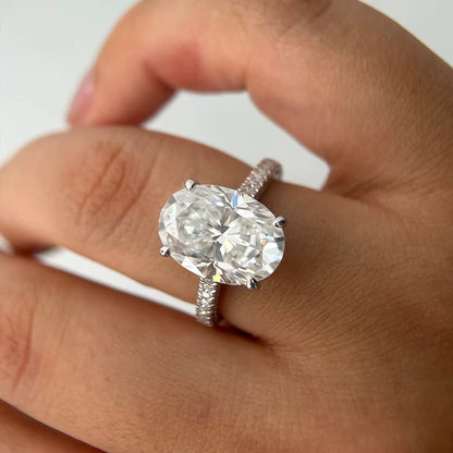 Bague solitaire en or blanc et diamants synthétiques portée au doigt d'une femme.