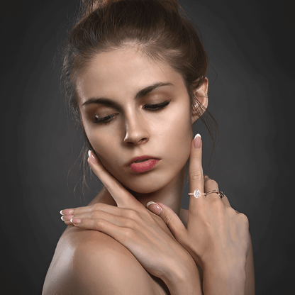 Bague solitaire en or rosé et diamant naturel portée au doigt d'une femme.