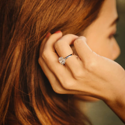 Bague solitaire en or blanc et diamant naturel portée au doigt d'une femme.