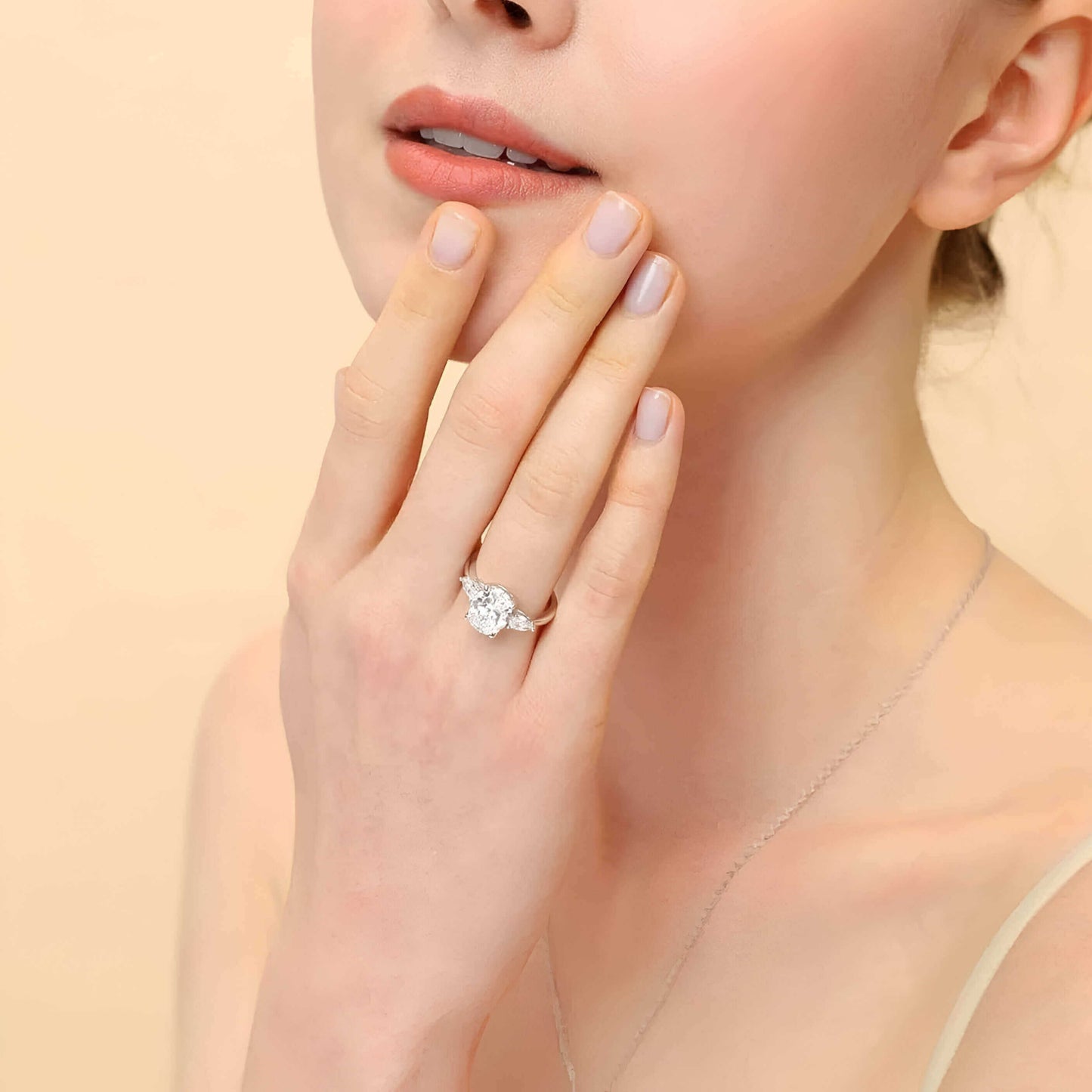 Bague solitaire en or blanc et oxyde de zirconium portée au doigt d'une femme.