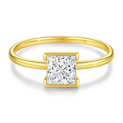 Bague solitaire princesse serti semi-clos en or jaune et diamant synthétique sur fond blanc.
