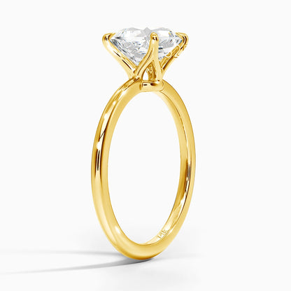 Bague solitaire quatre griffes en or jaune et diamant synthétique debout.