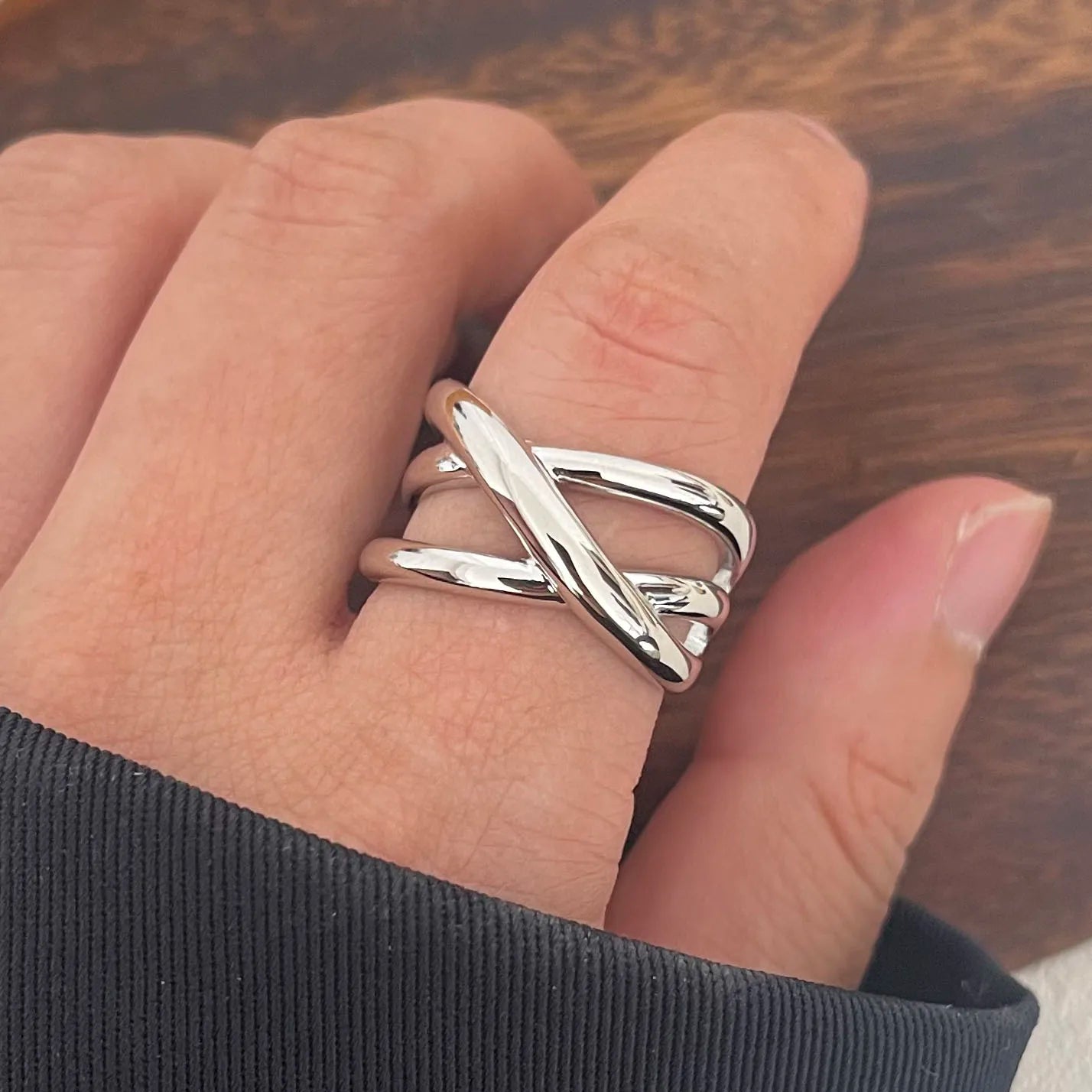 Bague triple croisement ajustable en argent sterling 925 plaqué or blanc portée au doigt d'une femme vue de proche.