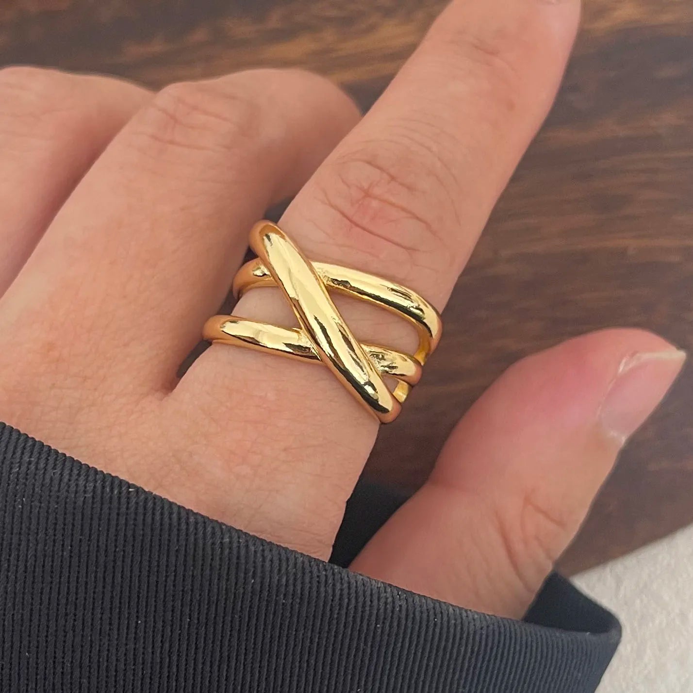 Bague triple croisement ajustable en argent 925 plaqué or jaune raffiné portée au doigt d'une femme vue de face.