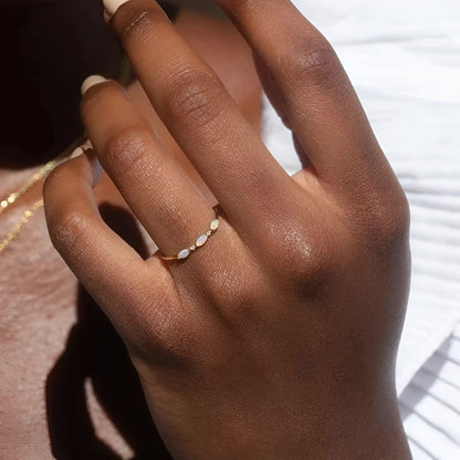 Bague triple opale fine Aurantis en argent 925 plaqué or jaune et diamants portée au doigt d'une femme vue de face.