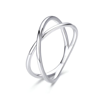 Bague X en or blanc sur fond blanc.