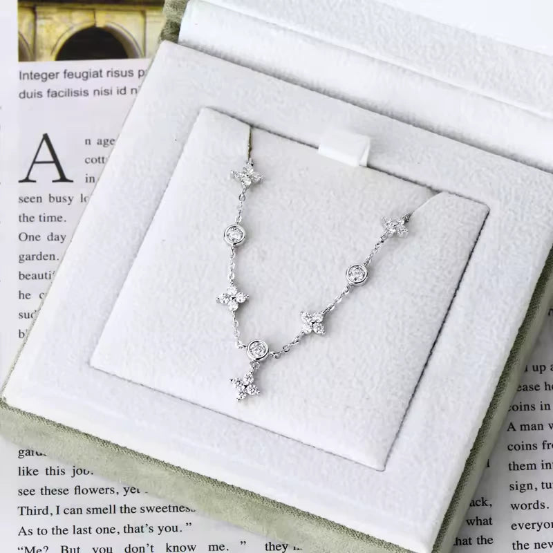 Bracelet à breloques en or blanc et diamants synthétiques dans son écrin.