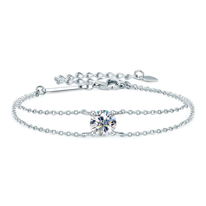 Bracelet chaîne double argentée en argent 925 plaqué or blanc et moissanite solitaire sur fond blanc.