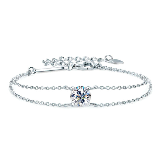 Bracelet chaîne double argentée en argent 925 plaqué or blanc et moissanite solitaire sur fond blanc.