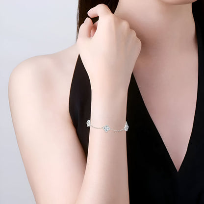 Bracelet chaîne trèfle à quatre feuilles en argent 925 plaqué or blanc et moissanites porté au poignet d'une femme vue de face.