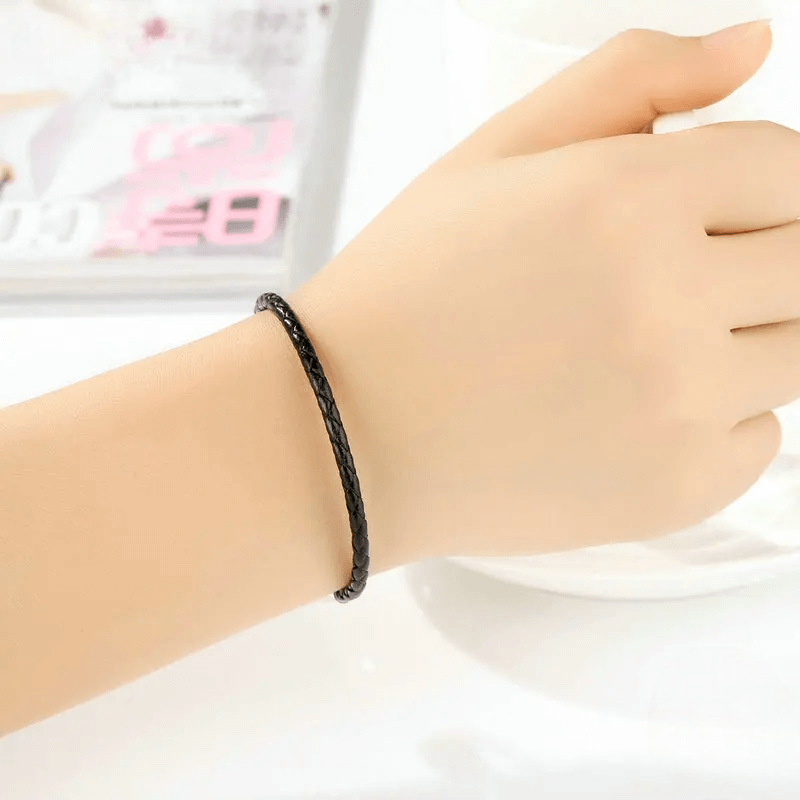 Bracelet clips en argent 925 et cuir noir porté au poignet d'une femme.