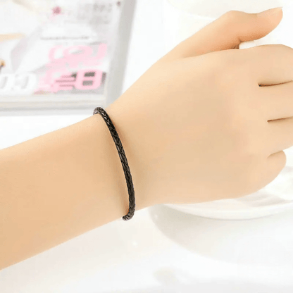 Bracelet clips en argent 925 et cuir noir porté au poignet d'une femme.