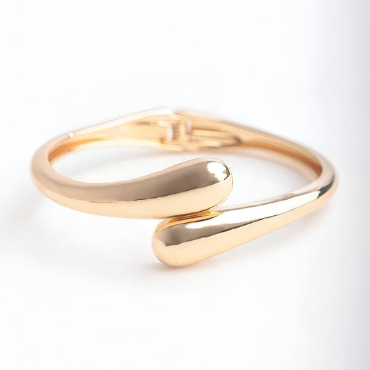 Bracelet courbe en alliage de zinc et or 14k sur fond blanc vue de face - bijou unique de luxe