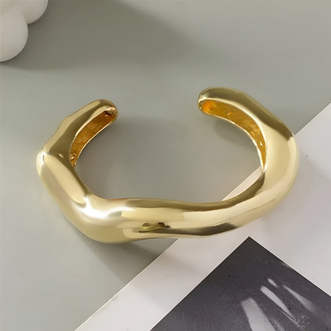 Bracelet Courbe Sculpté en alliage de zinc avec plaquage or 14K, présenté à plat sous lumière naturelle.