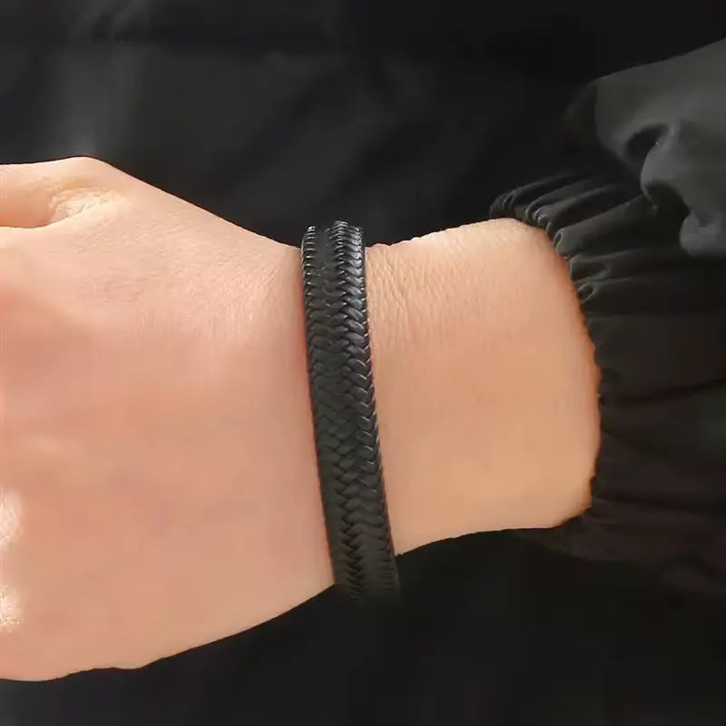 Bracelet en cuir tressé noir et acier inoxydable 316L noir porté au poignet d'un homme.