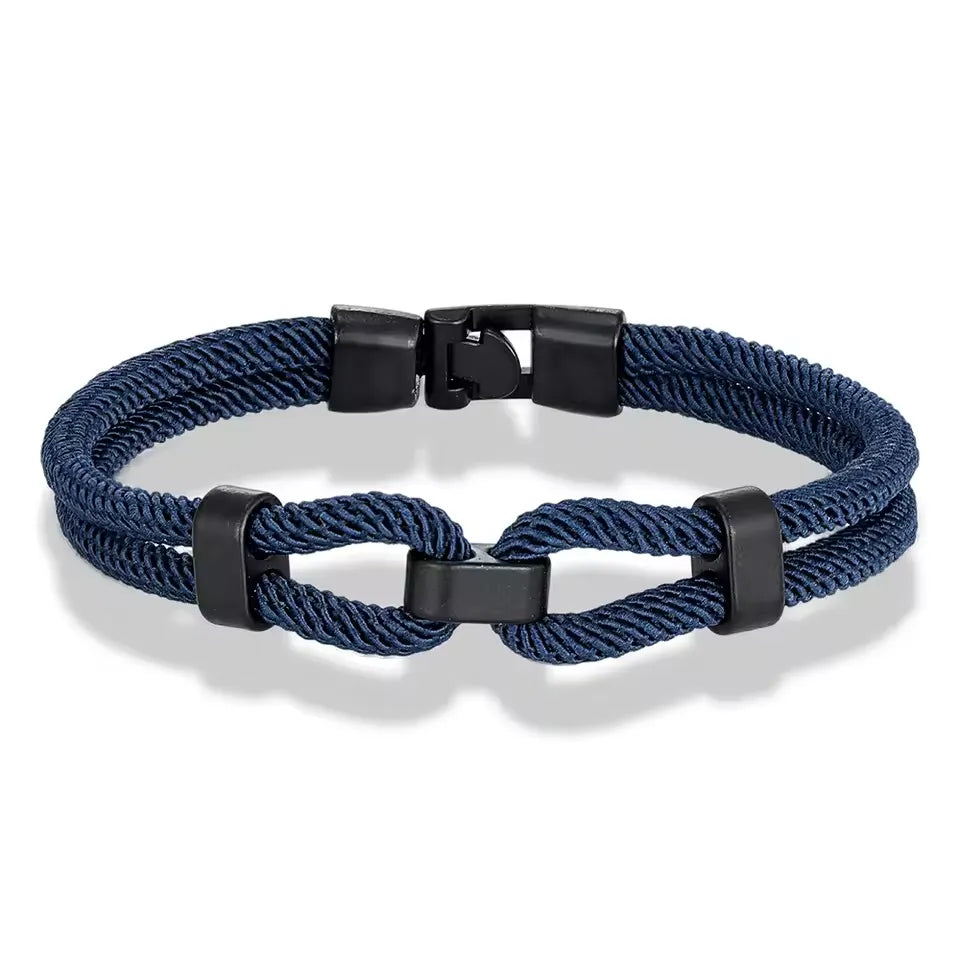 Bracelet double cordon bleu foncé fermoir loquet pivotant sur fond blanc.