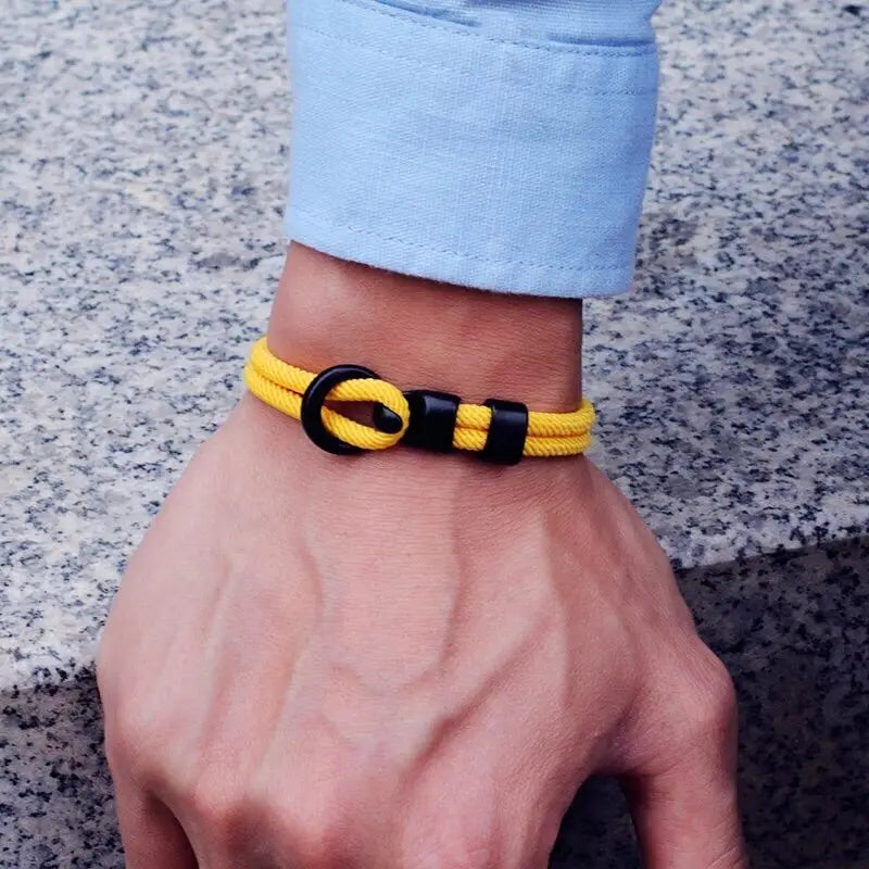 Bracelet double cordon jaune et fermoir crochet en zinc porté au poignet d'un homme.