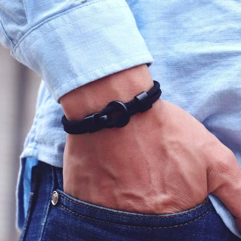 Bracelet double cordon noir et fermoir crochet en zinc porté au poignet d'un homme.