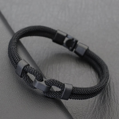 Bracelet double cordon noir fermoir loquet pivotant posé.