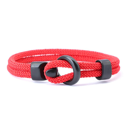 Bracelet double cordon rouge et fermoir crochet en zinc sur fond blanc.