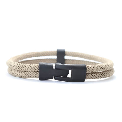 Bracelet double cordon loquet pivotant en zinc noir variante beige sur fond blanc.