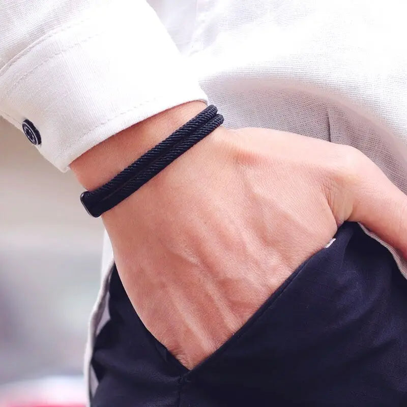 Bracelet double cordon loquet pivotant en zinc noir variante noir porté au poignet d'un homme.