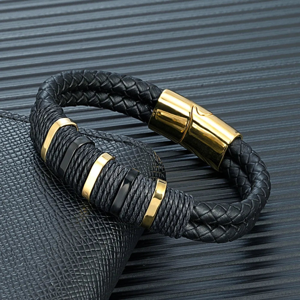 Bracelet double cordon en cuir noir et acier inoxydable plaqué or jaune posé.