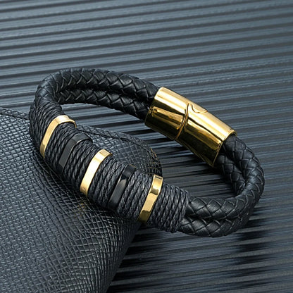 Bracelet double cordon en cuir noir et acier inoxydable plaqué or jaune posé.