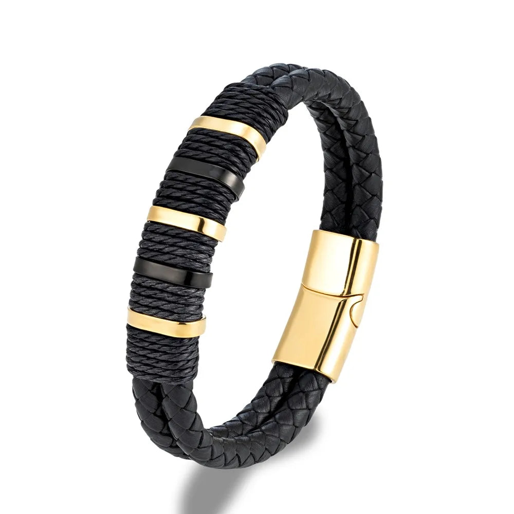 Bracelet double cordon en cuir noir et acier inoxydable plaqué or jaune sur fond blanc.