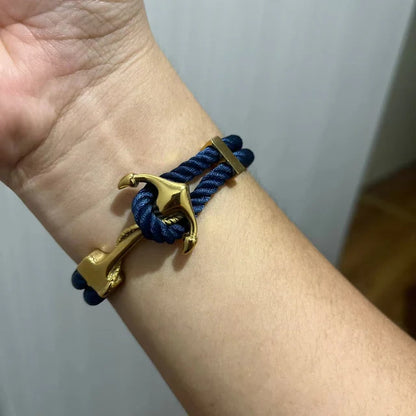 Bracelet encre en acier inoxydable plaqué or jaune variante bleu foncé porté au poignet d'une femme.