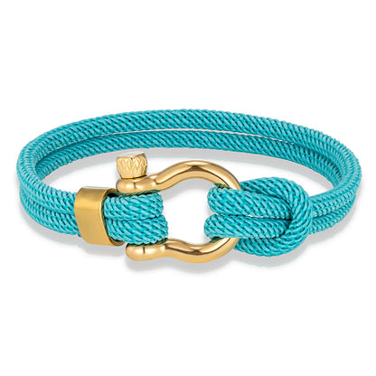 Bracelet cordon bleu ciel fer à cheval en acier doré sur fond blanc.