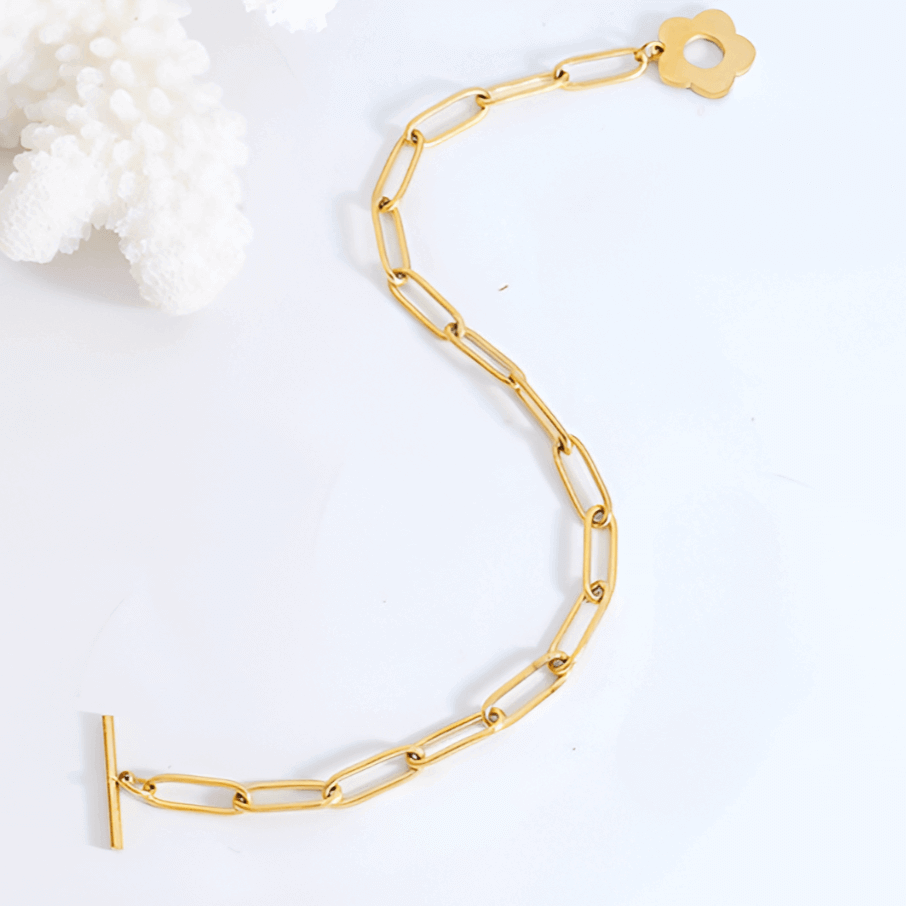 Bracelet fleur en acier plaqué or jaune à plat.