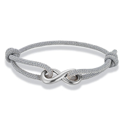 Bracelet infini ajustable en acier inoxydable blanc et cordon gris sur fond blanc.