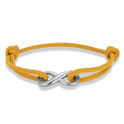 Bracelet infini ajustable en acier inoxydable blanc et cordon jaune moutarde sur fond blanc.